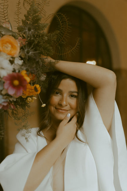 Bride holds wildflower bouquet over head.