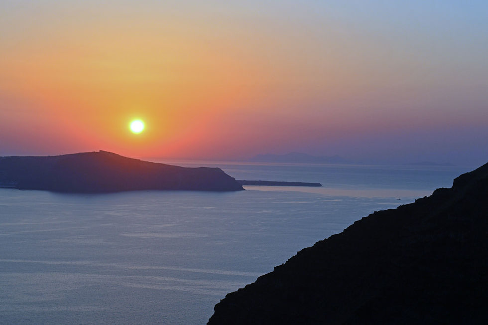 Vibrant orange and pink sunset sky reflecting over dramatic mountain terrain