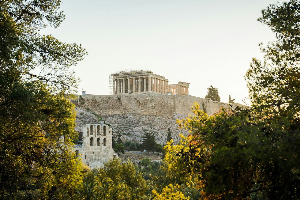 The Parthenon and Acropolis of Athens seen through golden-leafed trees in soft evening light, Greece.