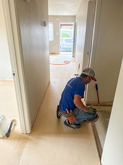 Professional flooring installer preparing the subfloor during a residential flooring installation, ensuring a precise and durable finish.