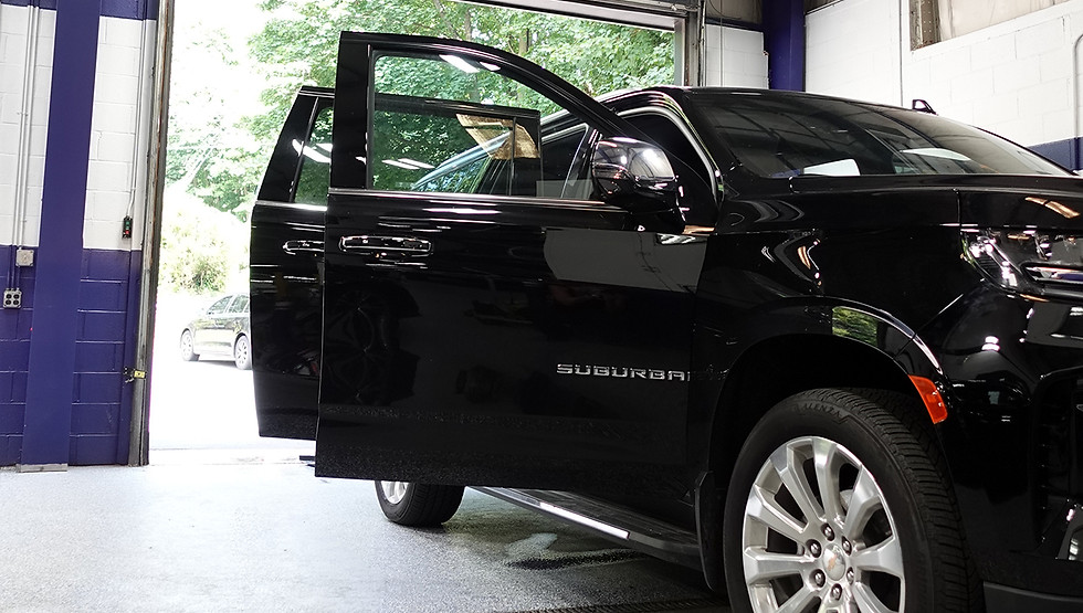 Side view of a black Suburban in the process of getting detailed