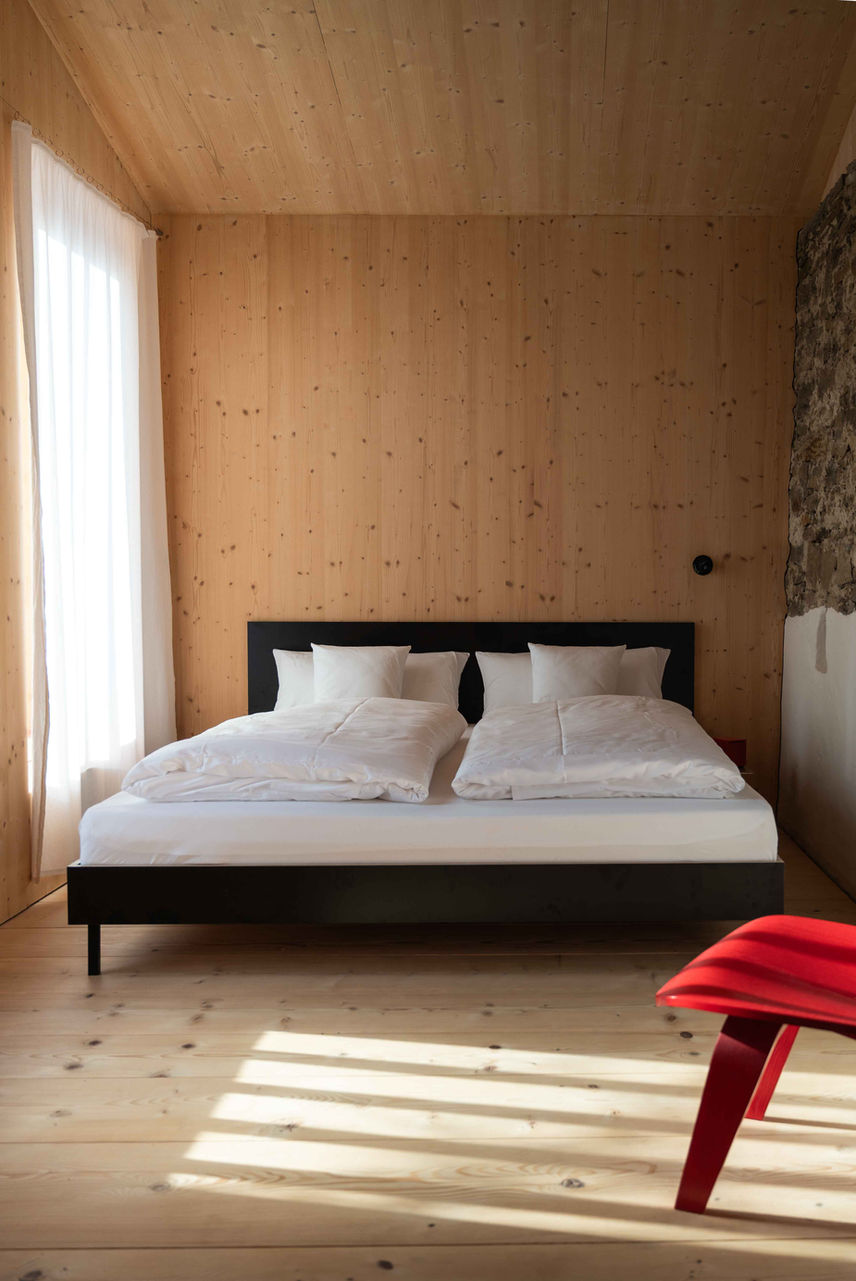 Modernes Schlafzimmer mit sanft beleuchtetem Bett und weißer Bettwäsche