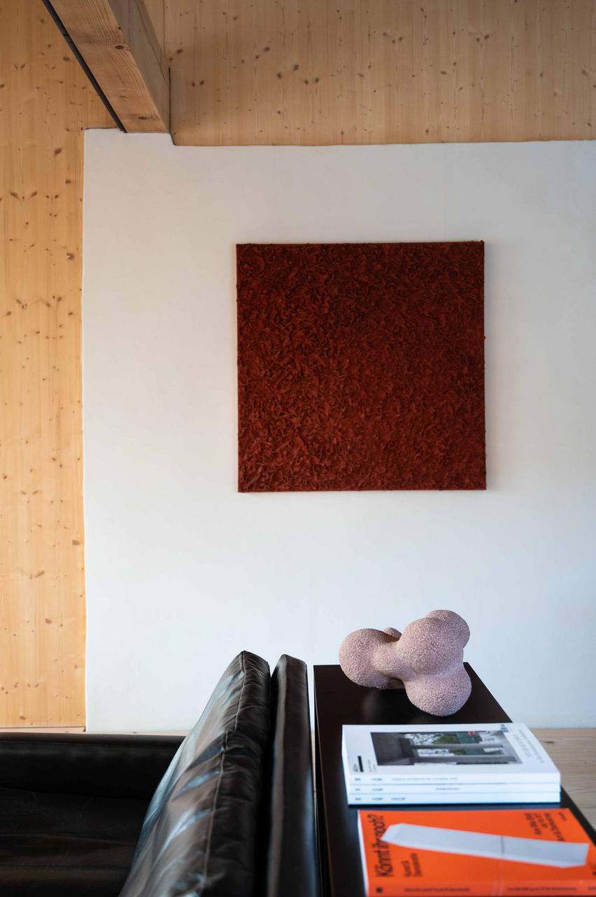 Modernes Wohnzimmer mit Ledercouch und rotem Gemälde an der Wand