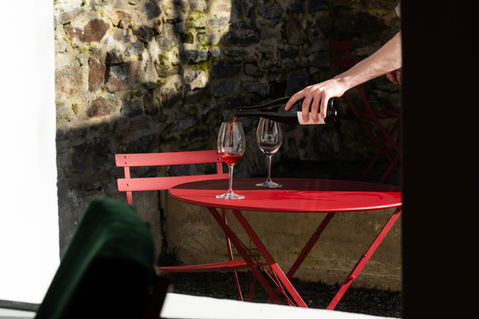 roter Gartentisch mit Weingläsern