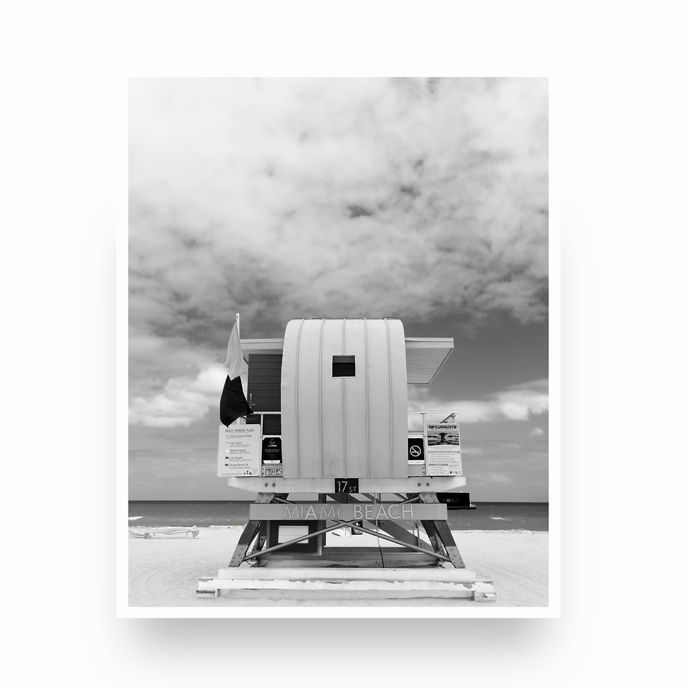 Thumbnail: Vertical black and white photo of a Miami lifeguard stand with a vast, cloudy sky above it.