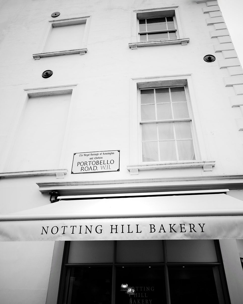 Black and white photo of the Notting Hill Bakery storefront and awning on Portobello Road.