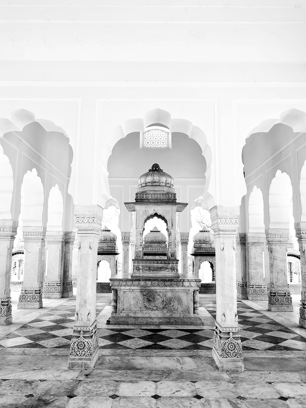 Vertical high-key black and white photo of a carved marble shrine and checkered floor in Gaitor Jaipur.