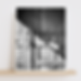 Vertical black and white photo of a vintage wooden door with a sign reading Happy Hour Starts Now.