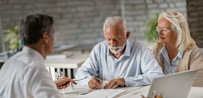 A senior couple is signing their estate plan documents with an attorney.