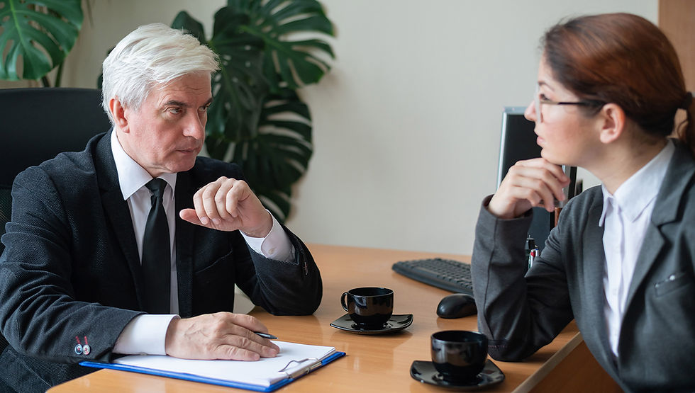 Senior business attorney meeting with a business owner at a desk.
