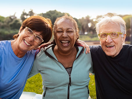 Three people smiling after getting dental implants.