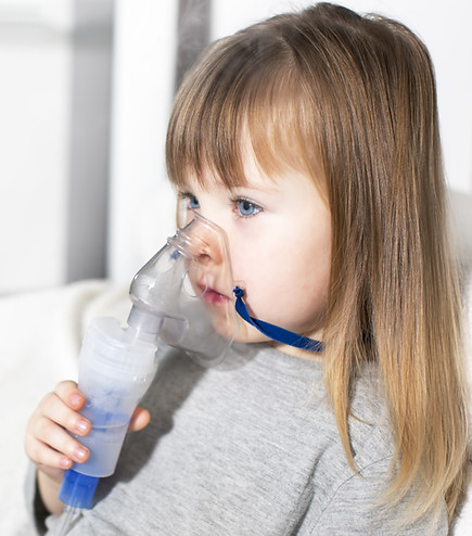 Young girl using an inhaler.