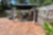 .Concrete patio with textured rust colored surface and canopy with furniture