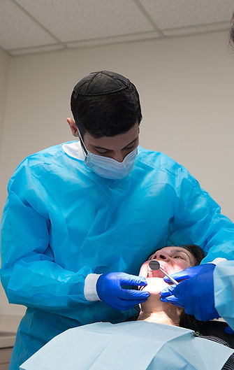 Dr. Kuyunov, Rochester, NY, Prosthodontist examining a dental implant patient.
