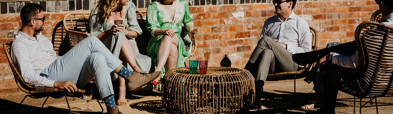 Guests gathered around rattan furniture at an outdoor wedding