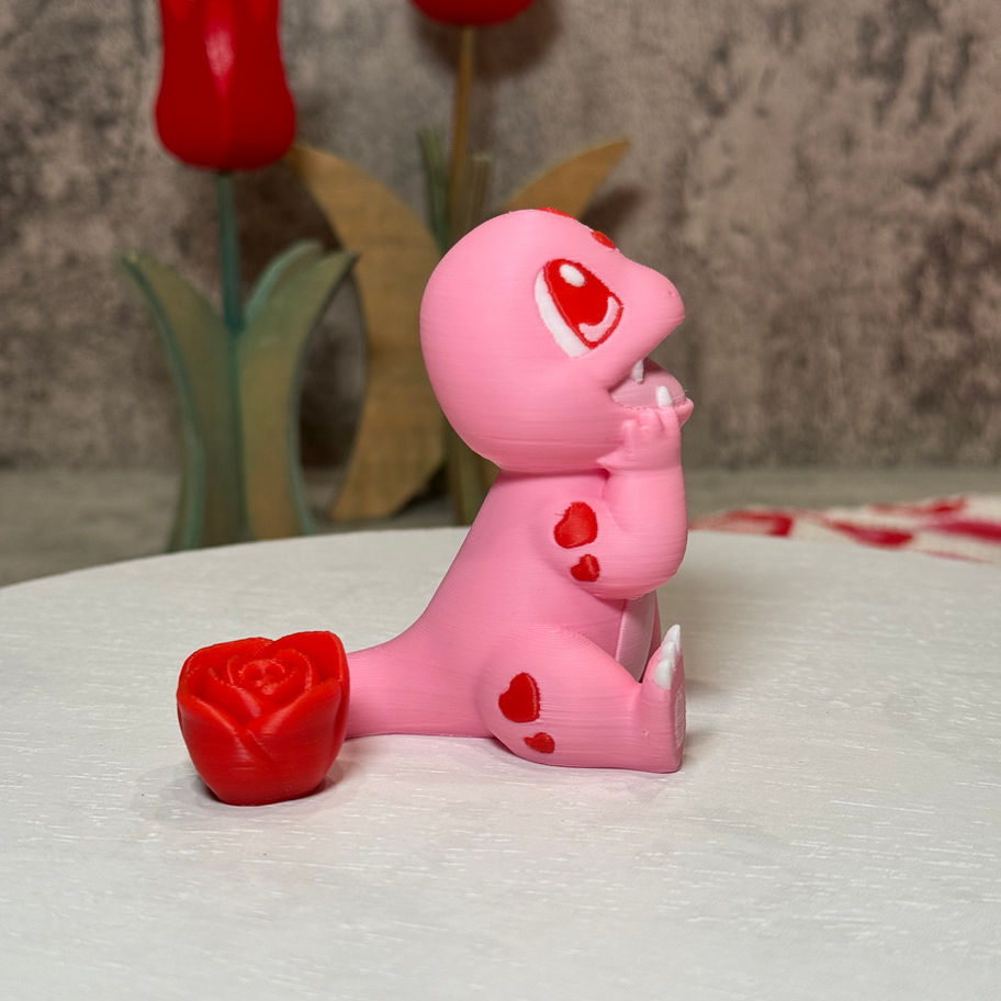 Pink Charmander with heart eyes, fangs, and a rose tail, sitting sweetly with its head resting on its hands.
