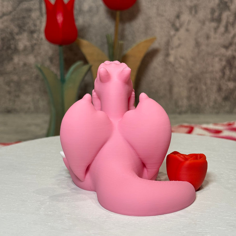 Pink Charizard with red eyes and a rose tail, resting its head on its hands in a cute, thoughtful pose.