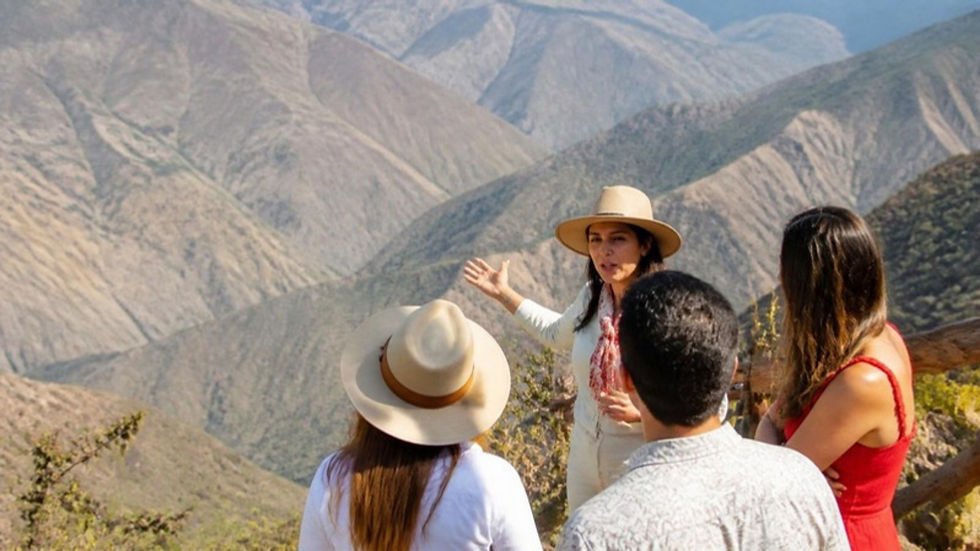 Guía turística santandereana explica el paisaje del cañón del Chicamocha a un grupo de visitantes.