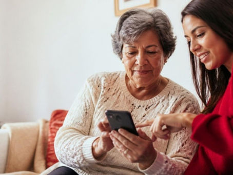 Mujer mayor usa una app financiera con ayuda