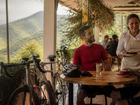 La dueña de un café de pueblo en el Valle del Cauca atiende a ciclistas aficionados en su terraza