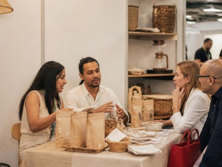 Empresarios conversan con compradores en un stand de productos artesanales en una feria de negocios en San Salvador