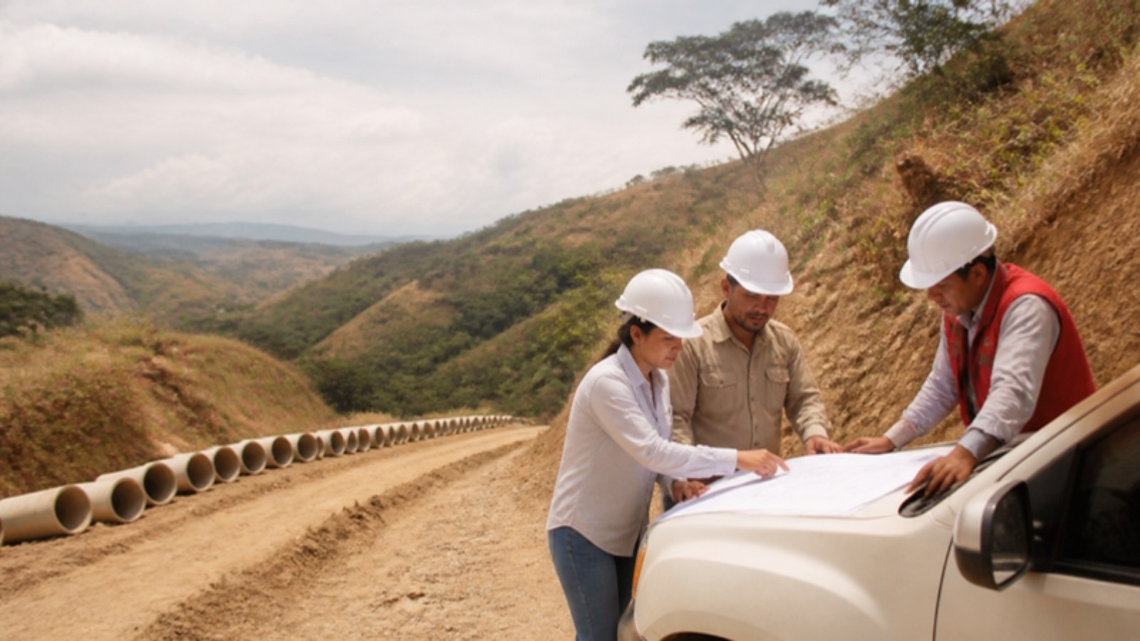 Equipo de una pequeña empresa de obras civiles revisa planos en la obra de un acueducto rural en el Huila.
