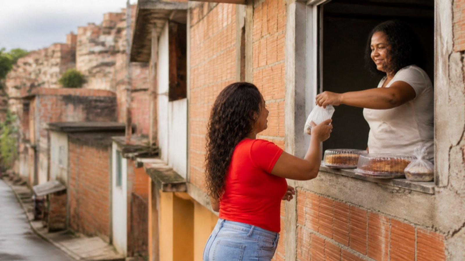 Emprendedora vende dulces caseros desde la ventana de su casa en un barrio popular de São Paulo.