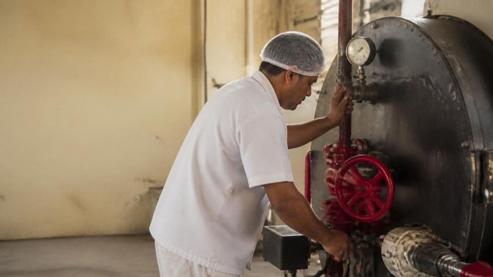 Operario de una planta de alimentos en Cartagena revisa la caldera a gas y su válvula