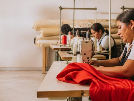 Costureras trabajan con máquinas de coser industriales en un taller textil de Lima, Perú.
