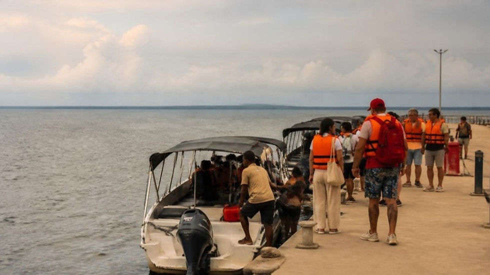 Turistas con chalecos salvavidas esperan para embarcar en lanchas en el nuevo muelle turístico de Buenaventura.