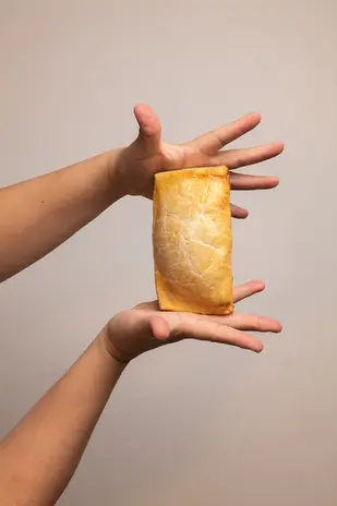 Creative studio shot of hands presenting baked pastry for social media content.
