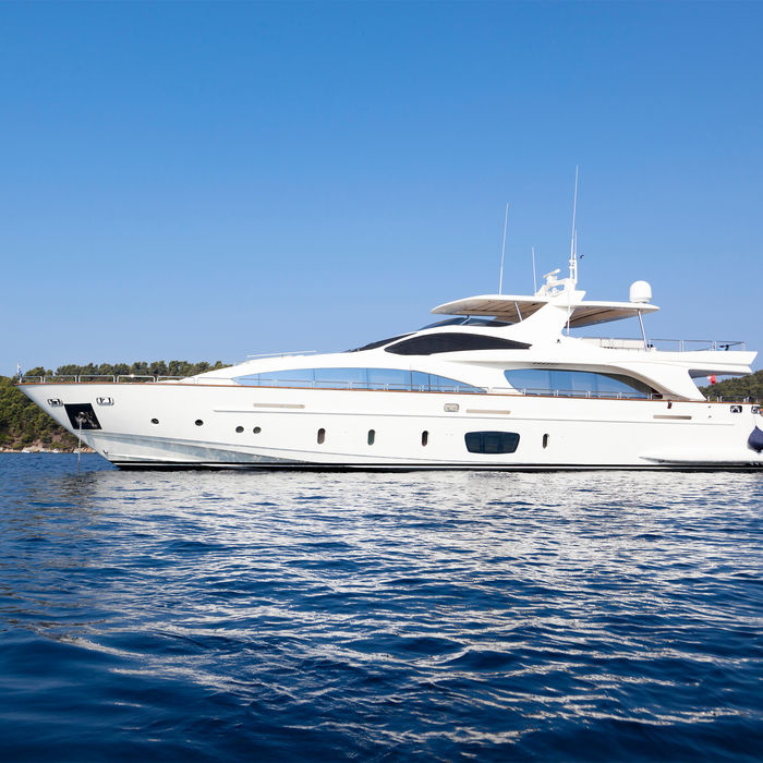 Large white luxury yacht cruising on deep blue water.