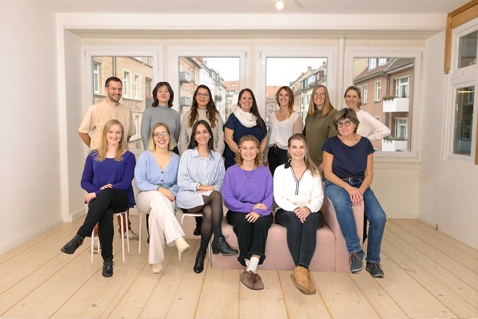 Team Familienspitex alle Mitarbeiter/innen stehen und Sitzen zusammen und schauen frontal in die Kamera - als Gruppenbild.