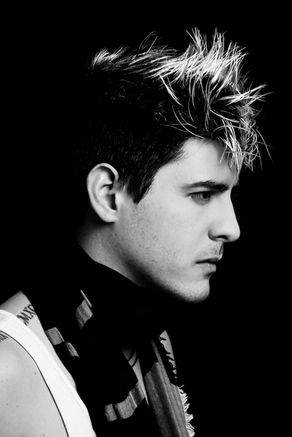 Portrait de profil d'un jeune homme en noir et blanc sur fond sombre, style lookbook et casting comédien.