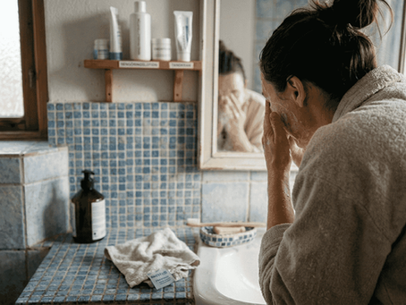 En kvinna tvättar ansiktet i det lilla badrummet inför sin behandling.