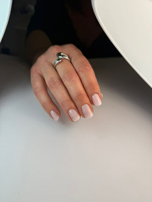 Main avec ongles manucurés sous une lampe