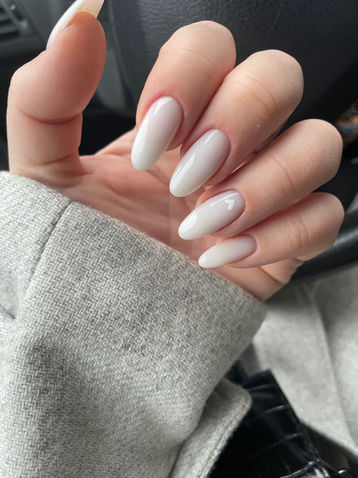Main avec manucure blanche et ongles ovales