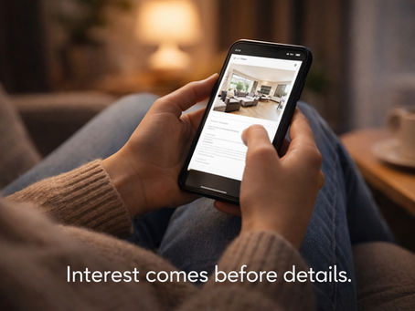 A woman holding a phone in her hand reviewing a home for sale posting