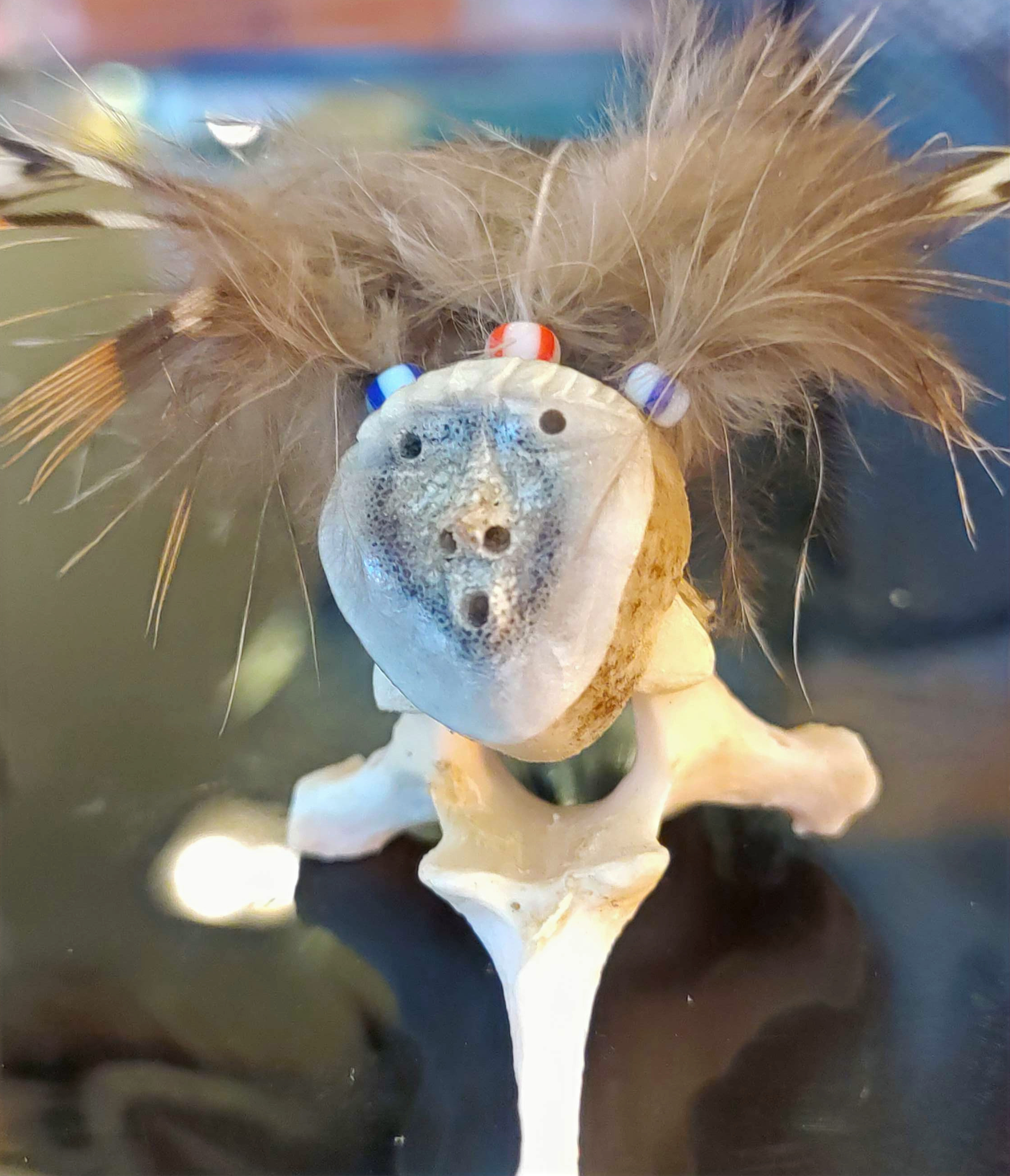 Hand-carved Bone Art Figure with Carved Face that Resembles a Wolf and Feathers