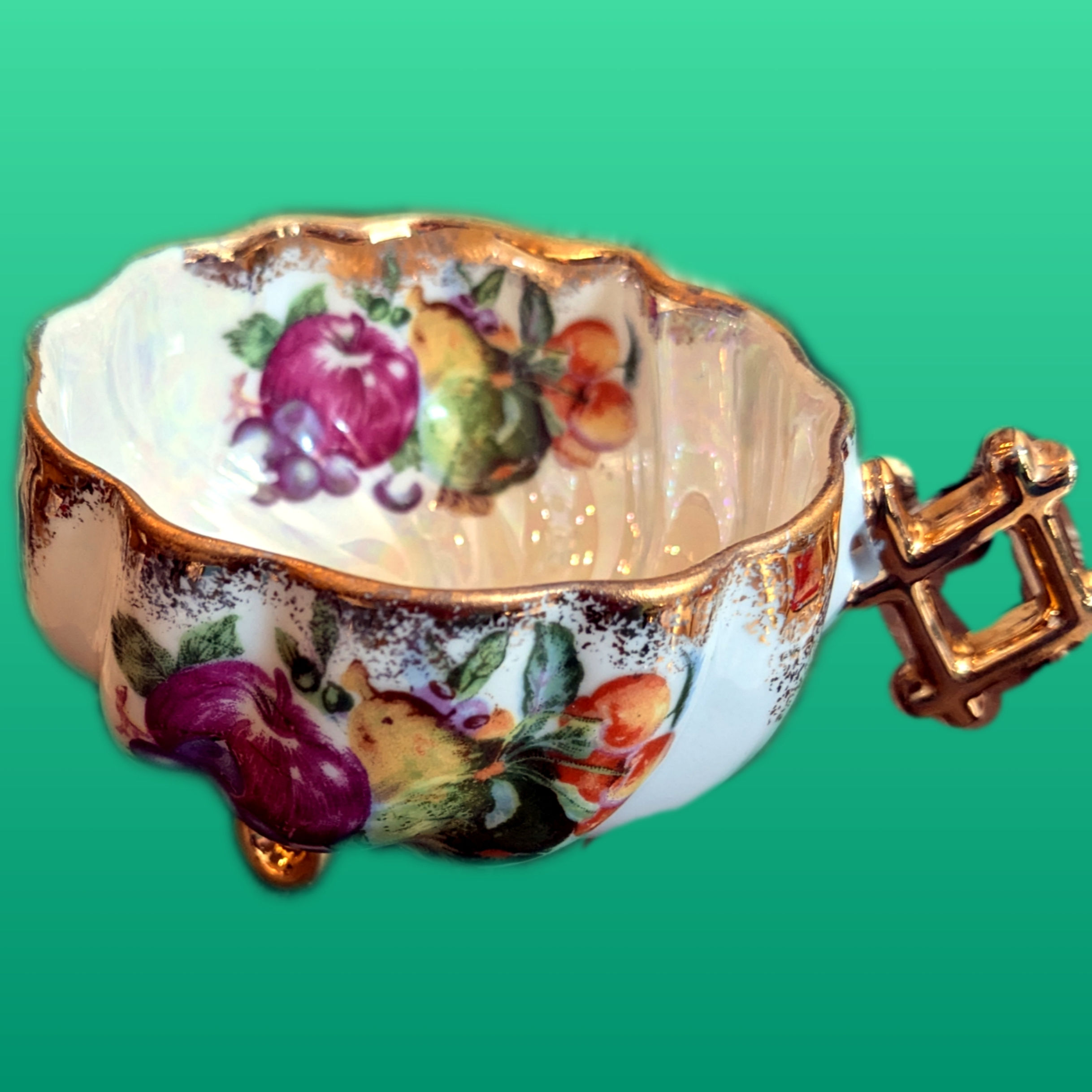 Unmarked Tea cup Features Fruit Motif and Gold Accents, Iridescent Background