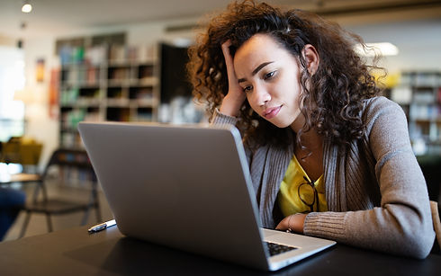 Concerned woman staring at laptop, hand on forehead