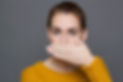 A woman covering her mouth due to halitosis