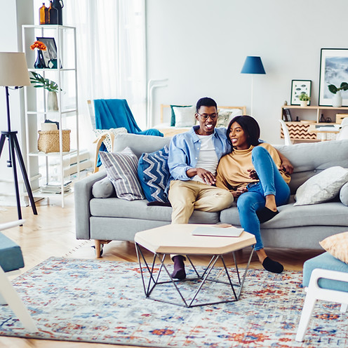 A couple sitting closely together on a couch in a cozy living room