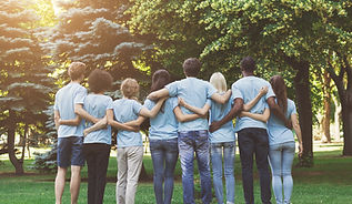 Group of happy volunteers embracing in park
