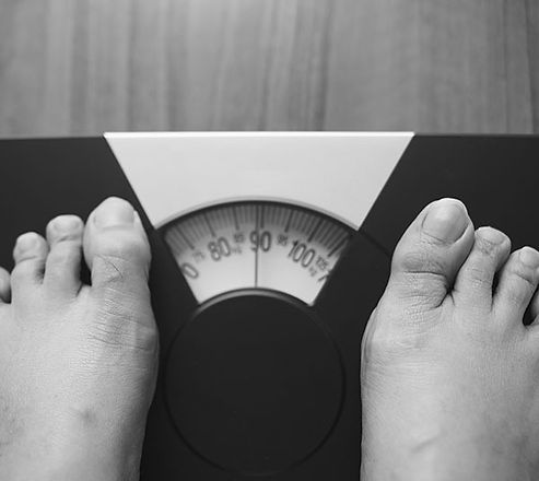 woman-feet-standing-weight-scale-wooden-background-600x600-1 (1).jpeg