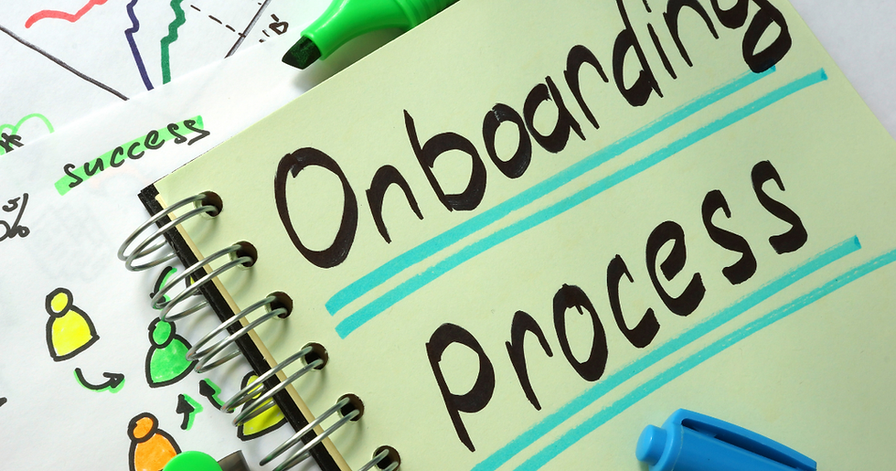 Notebook with "Onboarding Process" written in bold. Green highlights and doodles of people. Blue and green markers present. Mood is organized.