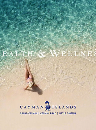 Woman relaxing on a pristine Cayman Islands beach with clear turquoise water, promoting health and wellness.