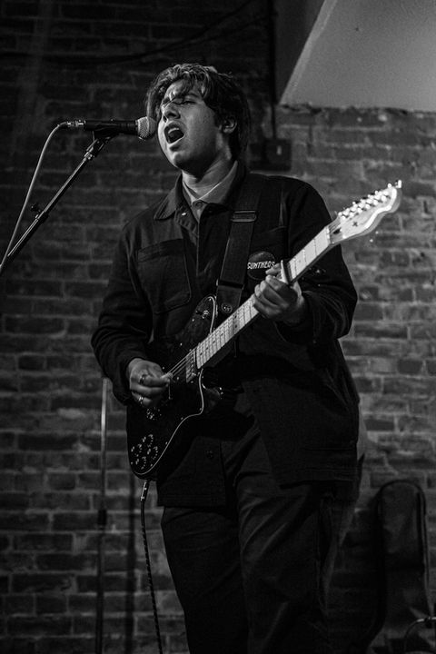 Person singing and playing guitar at a show