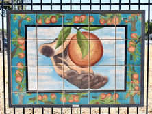 Hand holding peach; tile artwork