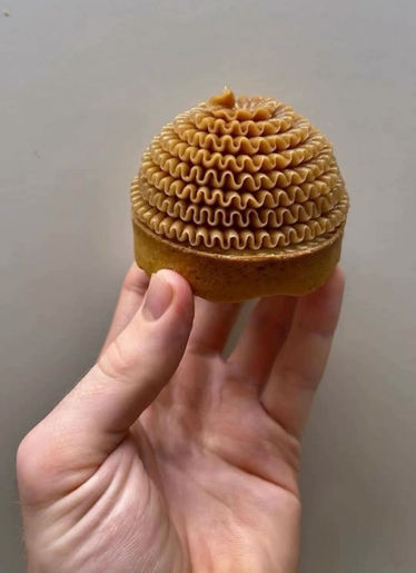 Hand holding a small golden dome with intricate ribbed texture